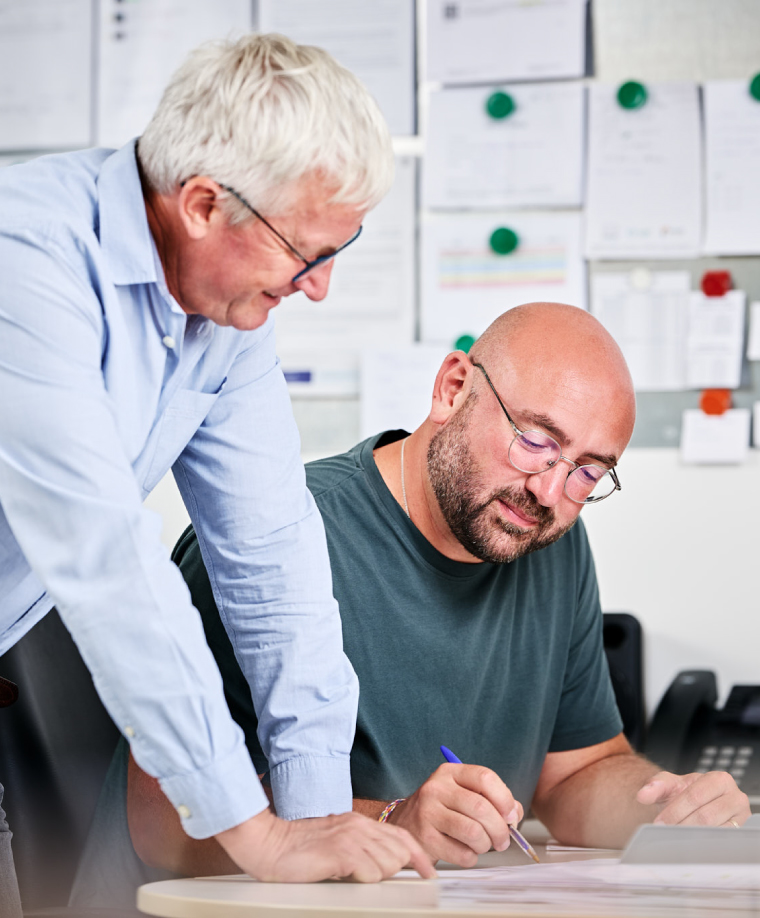 Gerd Steffens et Stéphan Hoss au bureau devant les plans d'une maison